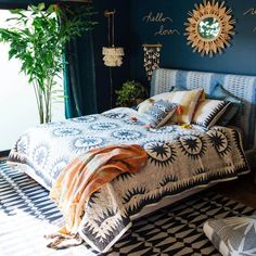 a bedroom with blue walls and patterned bedspread, potted plants on the wall