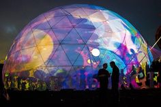 two people standing in front of an illuminated dome