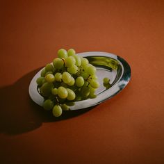 a bunch of grapes sitting on top of a metal plate