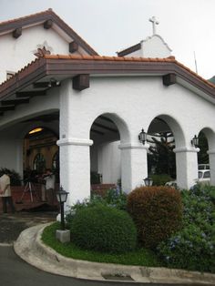 a white building with arched windows and a cross on the roof