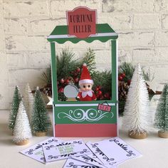 a christmas card with an elf on it and some cards in front of the card