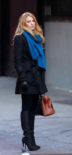 a woman is standing on the street with her purse