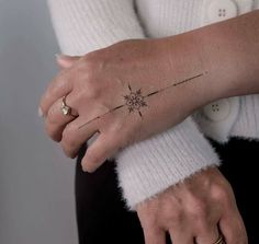 a woman's arm with a small tattoo on it