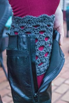 a woman wearing black leather pants with a crocheted pocket on the back of her leg