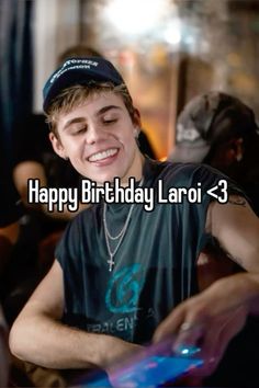 a boy is smiling while he looks at his cell phone with the words happy birthday laoi