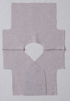 an unfinished piece of fabric with a hole cut in half to make a square shape