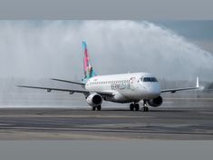 an airplane is spraying water on the tarmac