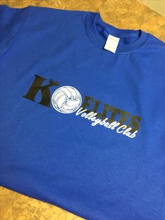 a blue t - shirt with the words kansas club on it and a volleyball ball