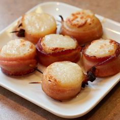 some food is on a white plate with toothpicks and other foods around it