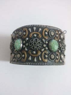 Large antique Italian repousse cuff bracelet fashioned from alpacca silver, with Czech Peking glass cabochons. Enclosed with a pin. In excellent condition, with no significant damages or wear. 7 inches inner circumference.1.5 inches wide. Antique Oxidized Cuff Bracelet As Gift, Antique Oxidized Finish Cuff Bracelet As Gift, Antique Oxidized Cuff Bracelet For Gift, Silver Cuff Bracelet With Cabochon, Unique Silver Cuff Bracelet With Cabochon, Antique Adjustable Cuff Bracelet With Patina, Silver Cabochon Cuff Bracelet In Vintage Style, Antique Silver Cuff Bracelet With Patina, Antique Silver Cabochon Bracelets