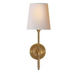 a wall light with a white shade on the side and a gold metal frame around it