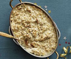 a casserole dish filled with meat and cheese on a blue tablecloth next to gold stars