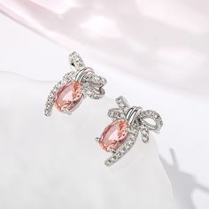 Romantic, enchanting and compassionate, the gentle pink blush of morganite creates a sense of calm and reflects the happier aspects of life. Inspired by vintage designs, these lovely earrings are crafted in sterling silver and showcase a beautiful bow with diamonds for a touch of sparkle. A wonderful gift or well earned treat for yourself.Carat Weight: 2.3 ctStone Size: 6*8 mmNumber of Stones: 2 Stone Shape: OvalStone Color: Fancy PinkCarat Weight: 0.934 ctStone Size: 1.3,1.1 mmStone Type: Jeuli Elegant Blush Earrings, Pink Sterling Silver Earrings Perfect For Her, Pink Sterling Silver Earrings For Her, Pink Round Crystal Earrings For Formal Occasions, Pink Sterling Silver Earrings As Gift For Her, Elegant Oval Peach Jewelry, Elegant Pink Earrings For Gift, Feminine Pink Earrings For Anniversary, Elegant Peach Oval Jewelry