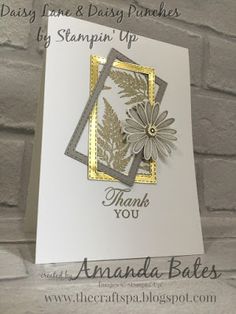 a white card with gold trimmings and a flower on the front that says, thank you