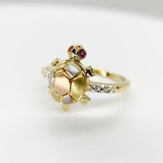 14k Solid Gold Turtle Tourmaline Tri Color Red Eye Moving Head Lucky CZ Ring for Women Girl * Metal : Real 14K Yellow Gold * Condition : Brand New * Finish : Polished * Height : 14.6 mm * Weight : 2.9 gram This is an approximate size & weight. Please expect up to ±10% difference. * Processing time : 1~2 business days * Ships from California This is 100% Authentic 14k Gold. Not plated or filled. All of our items are brand new and are shipped with a gift box. Gift Yellow Gold Multi-stone Diamond Ring, Yellow Gold Multi-stone Diamond Ring Gift, Stackable Cubic Zirconia Ruby Ring Gift, Stackable Ruby Ring With Cubic Zirconia For Gift, Fine Gold Multi-stone Ruby Ring, Fine Gold Ruby Ring With Multi-stones, Gold Cubic Zirconia Ruby Birthstone Ring, Gold Ruby Birthstone Ring With Cubic Zirconia, Yellow Gold Ruby Ring With 17 Jewels For Gift