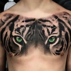 a man with green eyes and a tiger tattoo on his chest