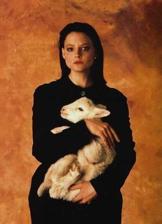 a woman holding a lamb in her arms