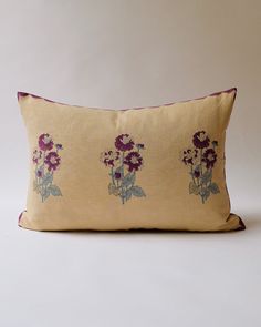 an embroidered pillow with purple flowers on it