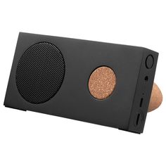 a black speaker with two brown speakers on it's side and an orange circle in the center