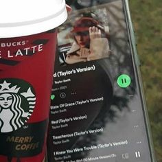 a cup of coffee sitting on top of a table next to a cell phone with the starbucks logo