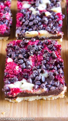 several pieces of dessert sitting on top of a wooden cutting board