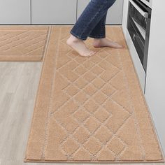 a person standing on a kitchen rug in front of an oven