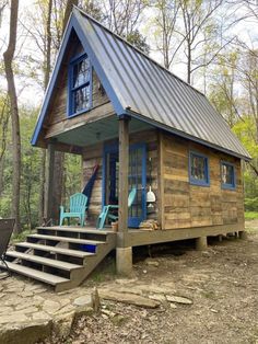 a small cabin in the woods with steps leading up to it