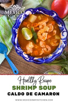 a bowl of shrimp soup with limes, tomatoes and cilantro on the side