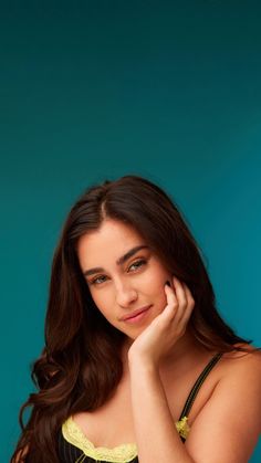 a beautiful young woman posing with her hand on her cheek