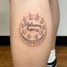 a woman's legs with a tattoo saying welcome home