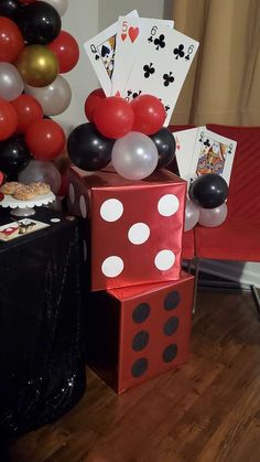 some balloons and cards are on the floor in front of a red box with white polka dots