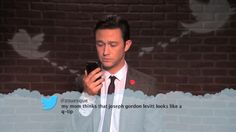 a man in a suit and tie looking at his cell phone with twitter on the screen