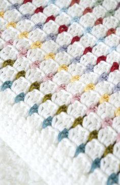 a crocheted blanket with multicolored squares on it's sides and bottom