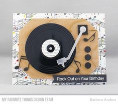 a birthday card with a record player and musical notes on the front, and an envelope that says rock out on your birthday