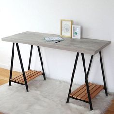 a table with two benches underneath it on a rug in front of a white wall