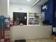 the front desk of a pharmacy with signs on it and shelves full of medical supplies