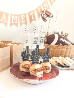 a plate with two sandwiches on it and some signs in the shape of hand signals