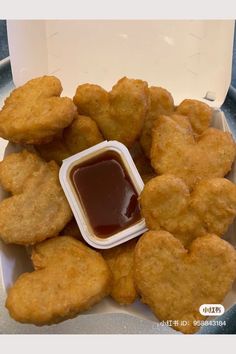 some fried food on a plate with ketchup in a container next to it