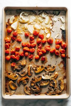 an overhead view of tomatoes and mushrooms on a baking sheet