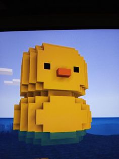 a yellow duck floating in the water on top of a flat screen tv