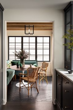 a dining room table and chairs in front of a window