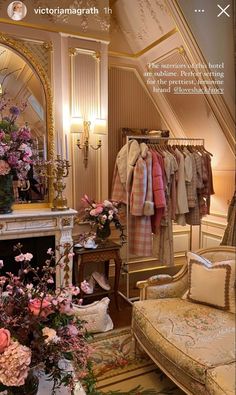 a living room filled with furniture and lots of pink flowers on top of a fireplace