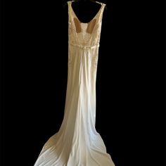 a white dress hanging on a black background