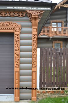 an ornate design on the side of a house in front of a wooden fence and gate