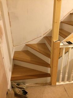 a pair of shoes sitting on the ground next to a stair case in a house