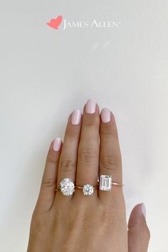 a woman's hand with two engagement rings on it