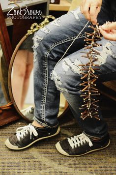 a person sitting on a chair with their feet in the air while tying up laces