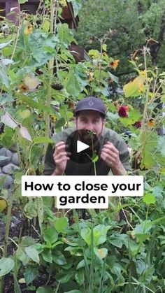 a man holding a camera in front of some plants