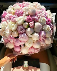 a bouquet of pink and white flowers sitting on top of a table