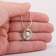 This "Aruba" pearl pendant necklace is handmade of 925 Sterling Silver. It has been hand crafted and cast in pure 92.5% solid silver in my workshop using a technique called water casting. I melt silver and pour the molten silver into cold water! The resulting organic shape creates a cup that imitates nature in a beautiful way. Finally, the lovely cultured pearl is set inside the cup to create this unique pendant.Pearl color: white Pendant size: approx 3/4 inch (20 mm) diameter The pendant hangs Silver Necklace With Pearl, Silver Pendant Necklace Unique, Silver Pearl Necklace, Silver Snake Chain, Buddhist Art, Pearl Pendant Necklace, Unique Pendant, Pearl Color, Necklace Sterling Silver